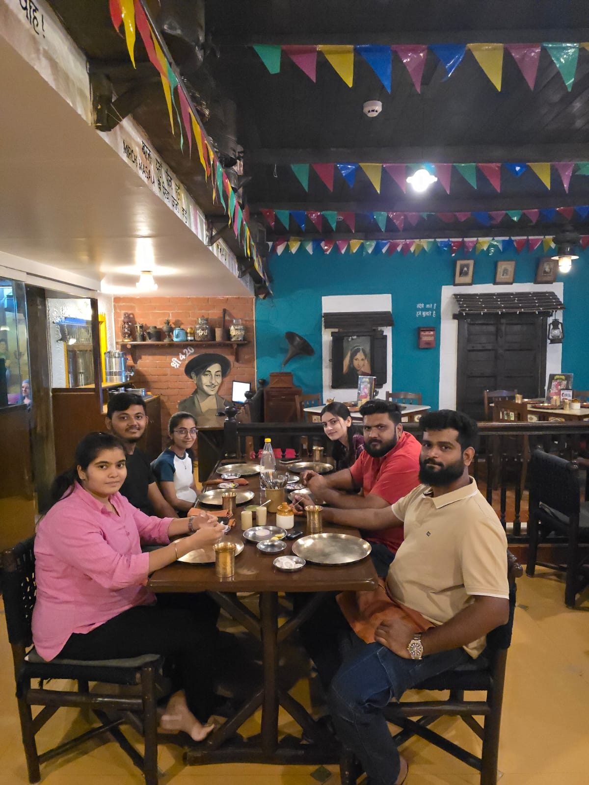 Six team members sharing a dinner at a colourful traditional restaurant with festive bunting overhead