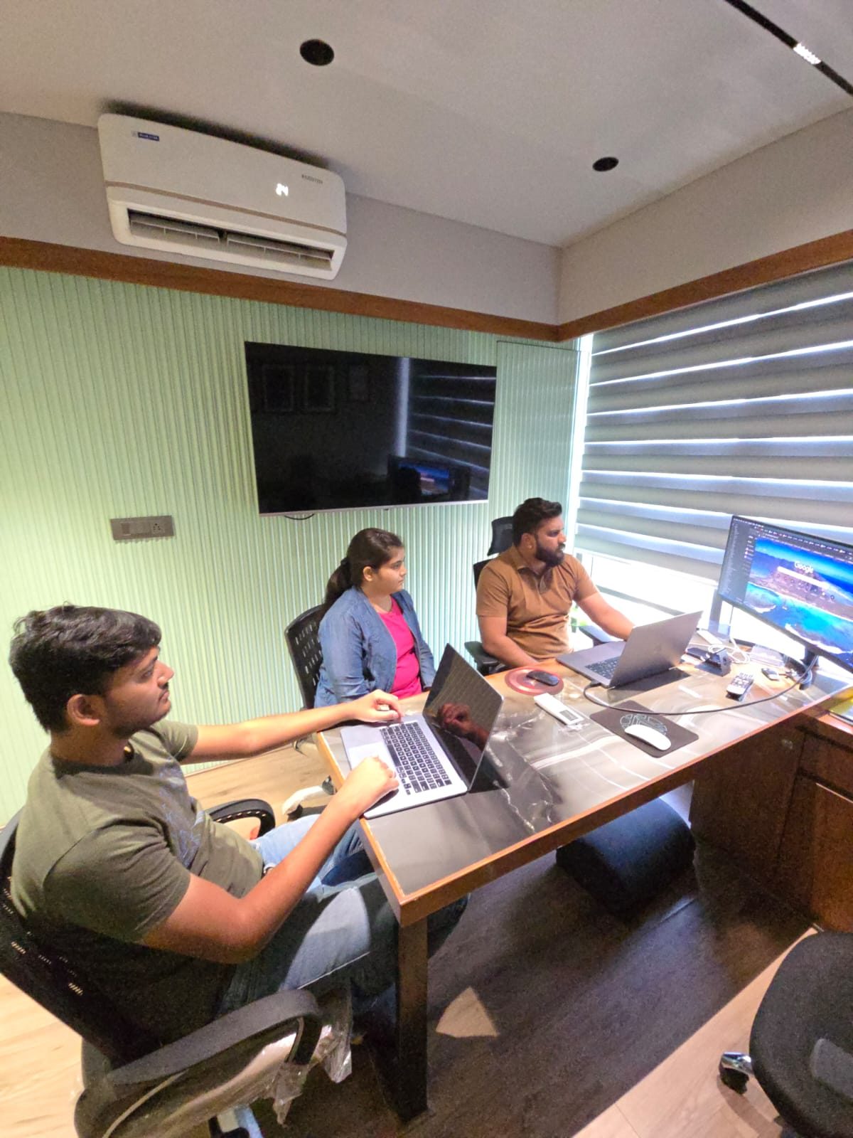 Three engineers focused at their laptops and monitors during a deep-work session at the Ahmedabad office